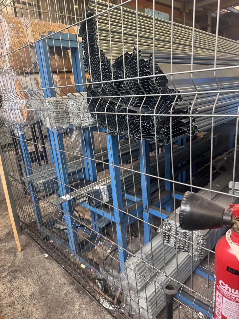 Perfiles y lamas de persiana metálica ordenados en estanterías en el almacén propio