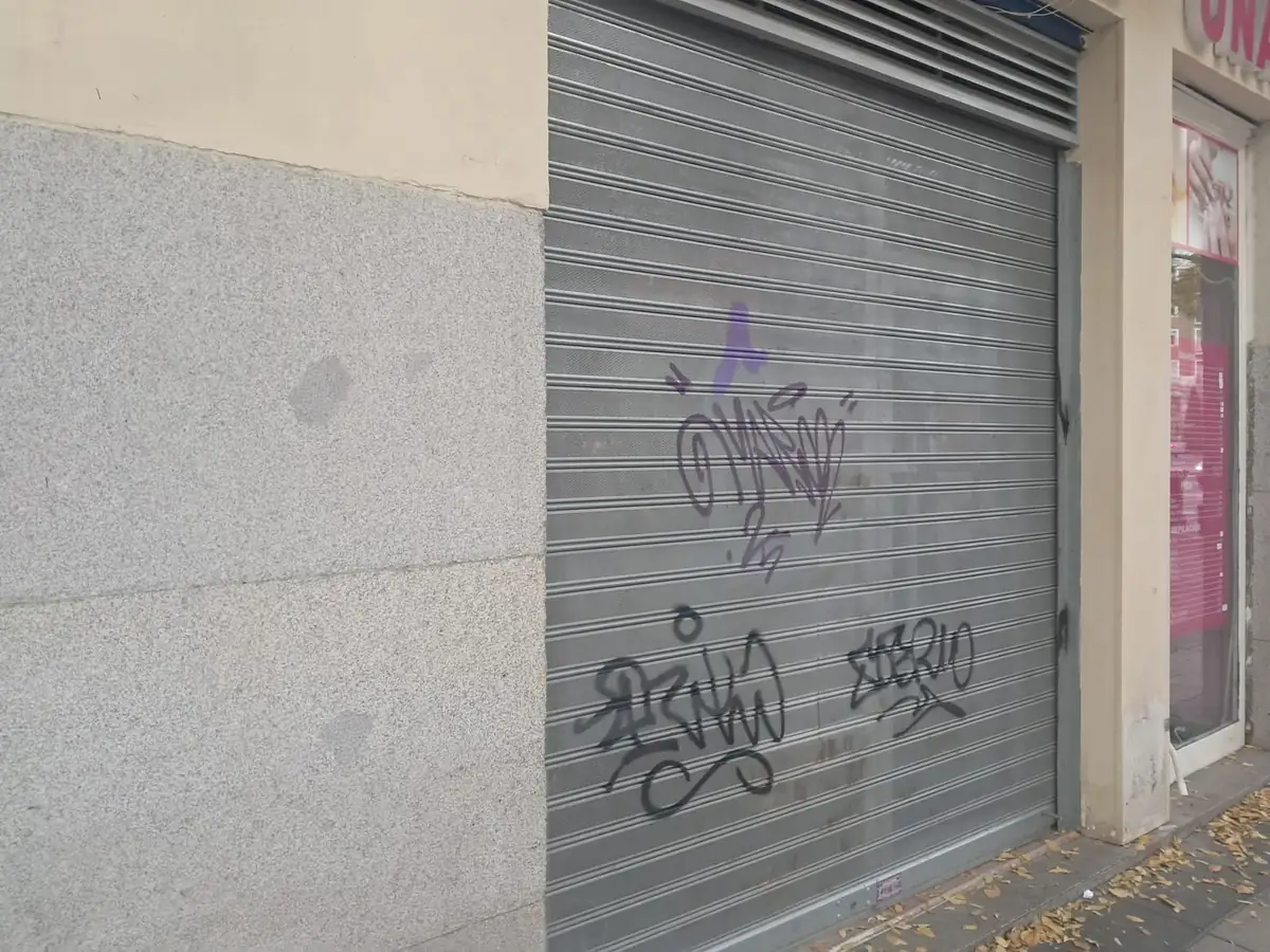 Persiana metálica microperforada bajada delante de un comercio de Barcelona