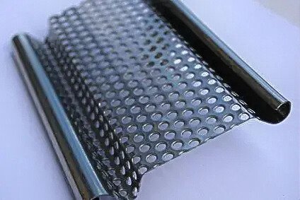 Detall de lama microperforada metàl·lica per a persiana comercial, amb petits forats que permeten visibilitat i il·luminació. persianes metàl·liques per a locals